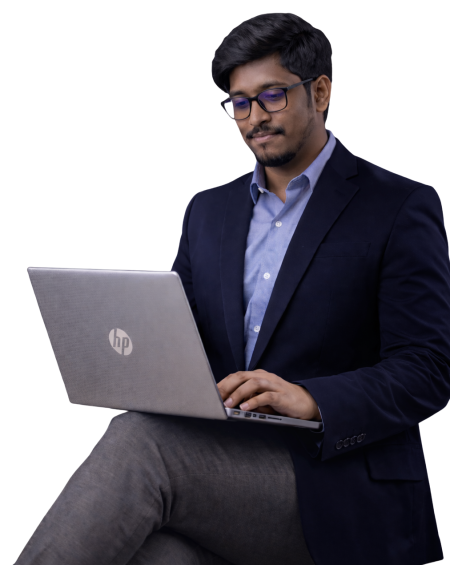prokhor-sikder-in-a-navy-blazer-using-a-laptop-while-looking-down-at-the-screen-on-a-dark-background